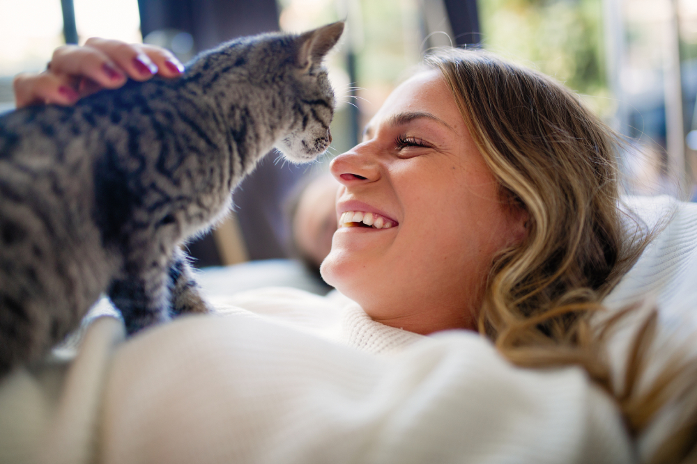 Young woman lying on the bed resting with her cat.